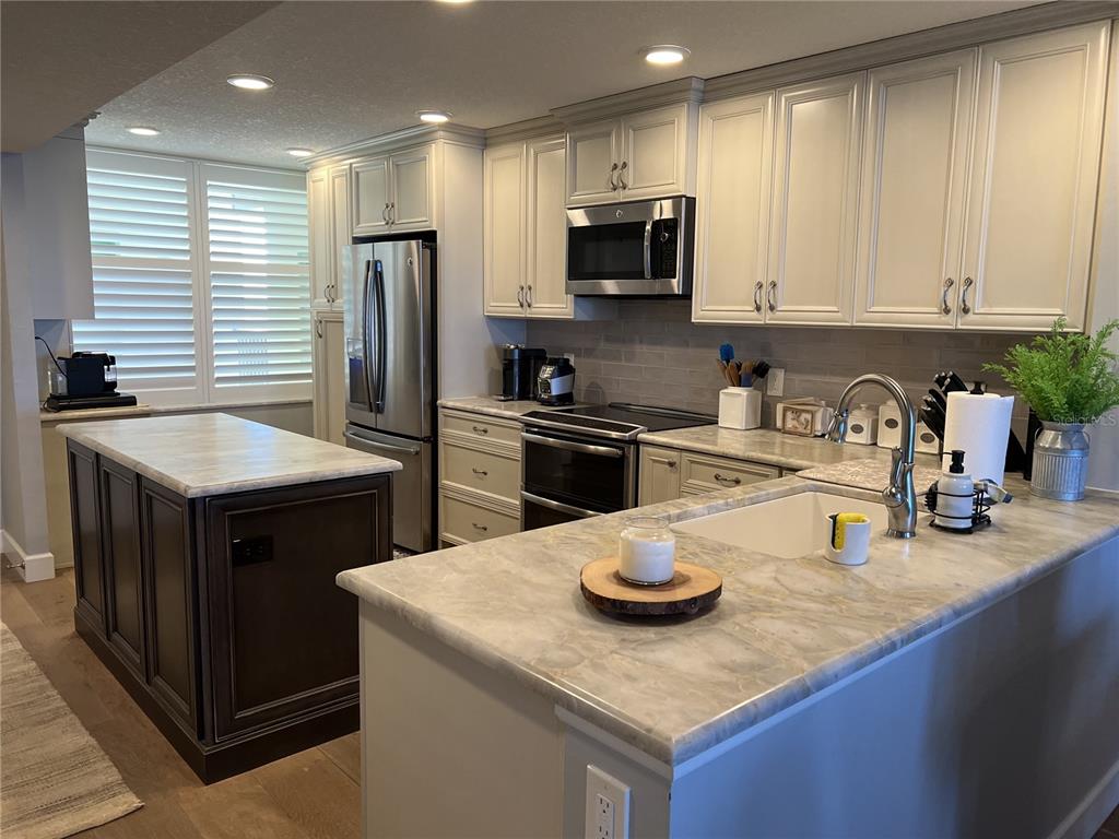 7100 Sunset Way, Unit PH5 St. Pete Beach, FL 33706 - Photo 6 of 32 a kitchen with stainless steel appliances granite countertop a sink stove and refrigerator