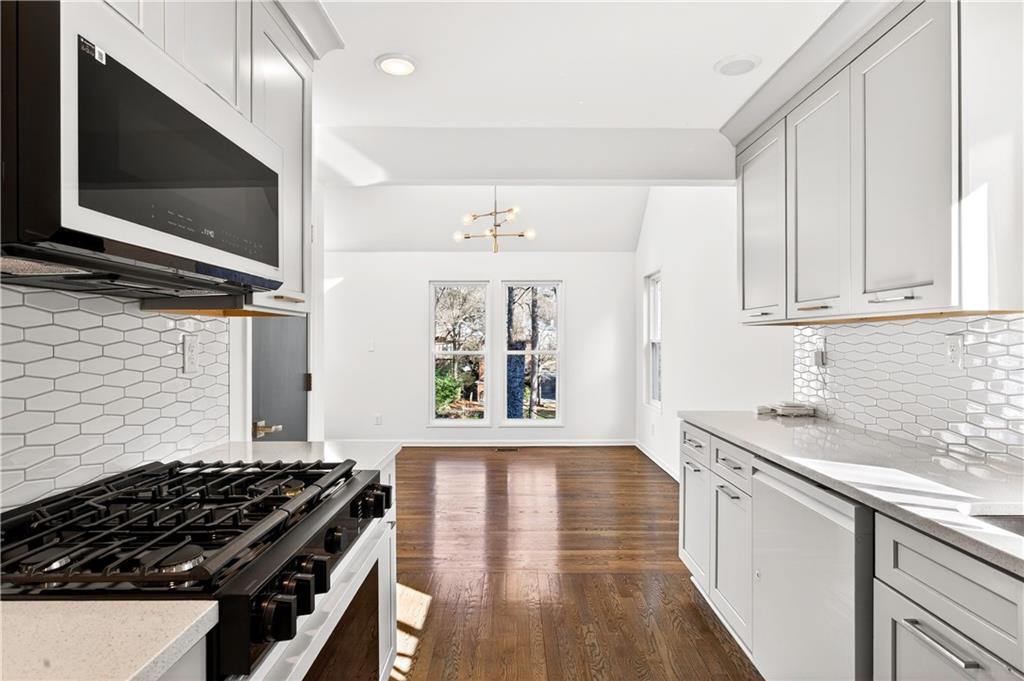 Undisclosed Address Brookhaven, GA 30319 - Photo 15 of 63 a kitchen with stainless steel appliances kitchen island granite countertop a stove and a wooden floor