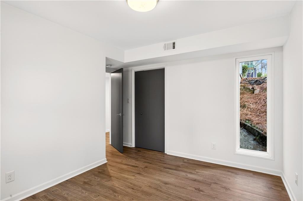 Undisclosed Address Brookhaven, GA 30319 - Photo 41 of 63 an empty room with wooden floor and windows