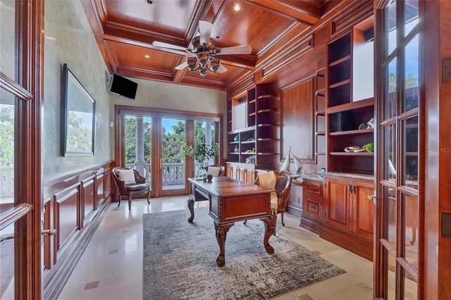 a bedroom with a bed a flat screen tv and a large window