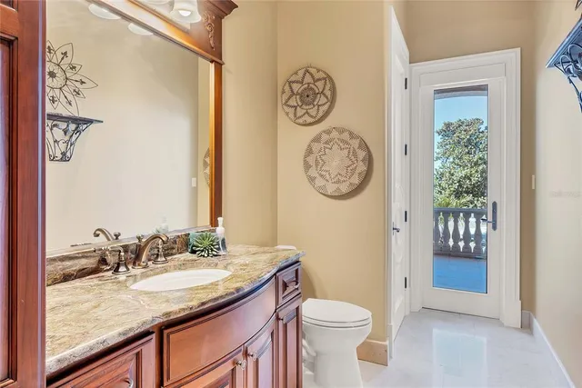 a bathroom with a granite countertop sink a toilet and shower