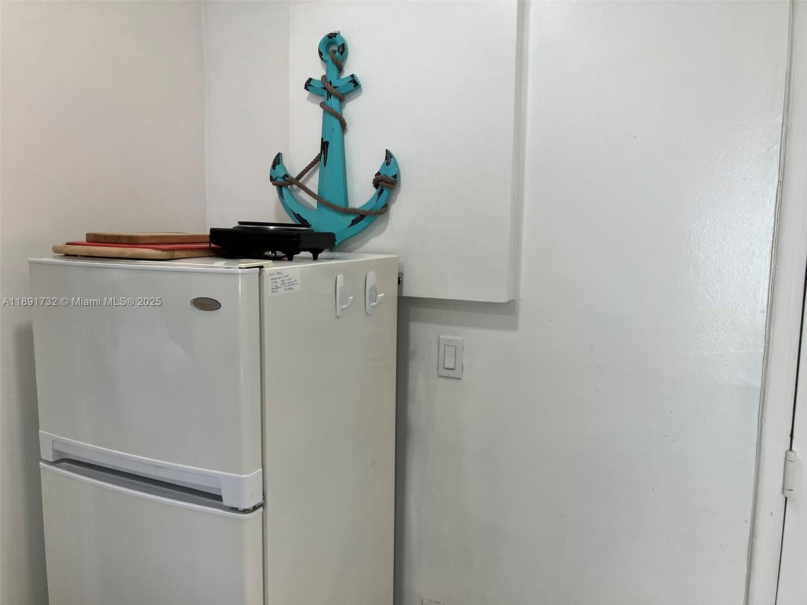335 Ocean Drive, Unit 306 Miami Beach, FL 33139 - Photo 12 of 34 a white refrigerator freezer sitting inside of a kitchen