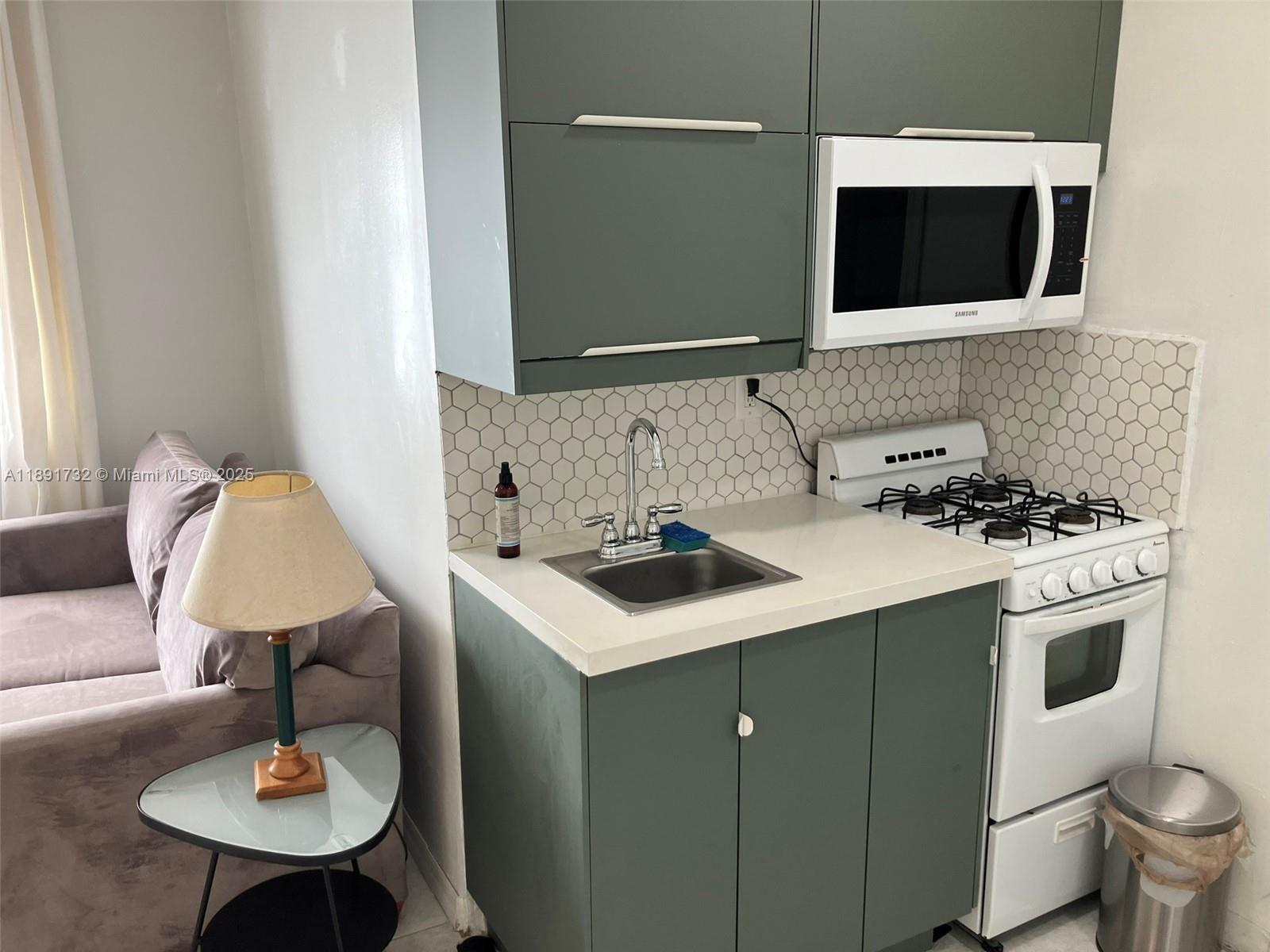 335 Ocean Drive, Unit 306 Miami Beach, FL 33139 - Photo 6 of 34 a kitchen with a sink cabinets and appliances