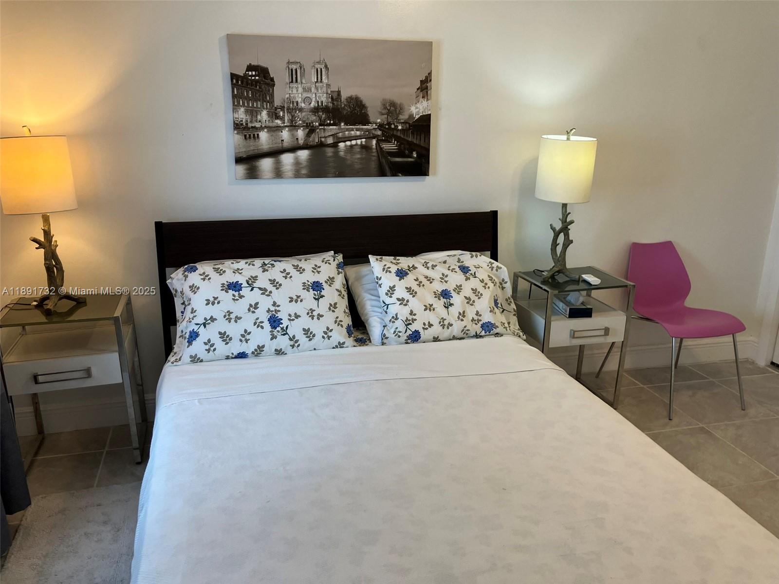 335 Ocean Drive, Unit 306 Miami Beach, FL 33139 - Photo 7 of 34 a bedroom with a bed and a lamp on dresser