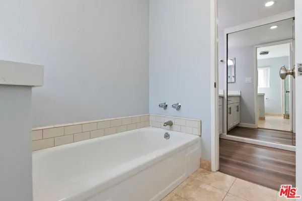 a white bath tub sitting next to a shower