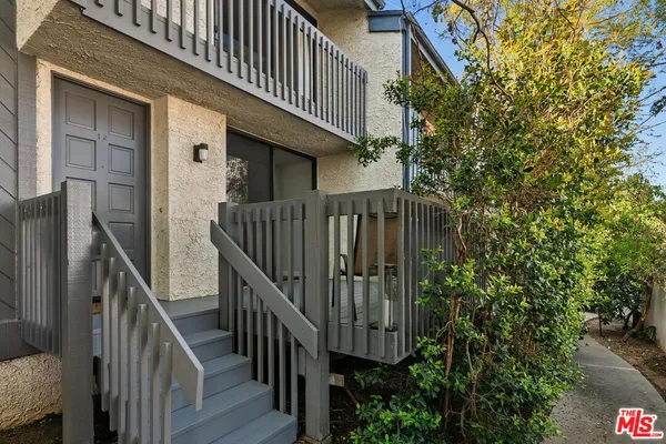 a view of balcony with lots of plants and wooden fence