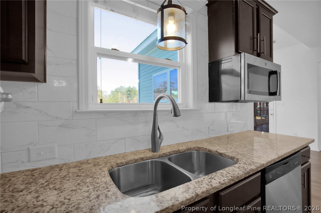2145 Harrington Road Fayetteville, NC 28306 - Photo 22 of 50 a kitchen with granite countertop a sink and a microwave