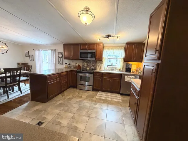 a kitchen with stainless steel appliances granite countertop a sink counter space cabinets and a large window
