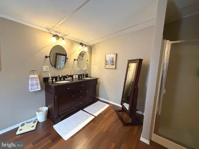 a living room with furniture mirror and wooden floor