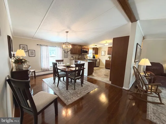 a view of a dining room with furniture a chandelier and wooden floor