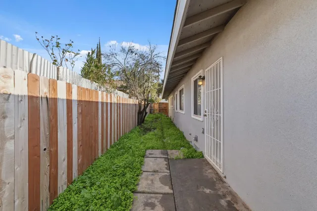 a view of a pathway of a house with wooden fence