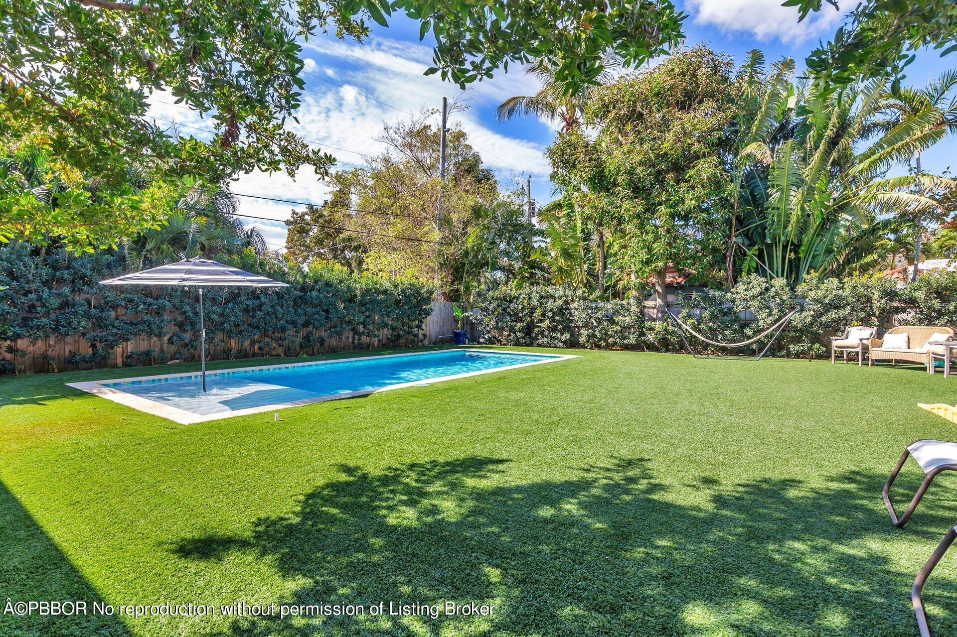 356 Potter Road West Palm Beach, FL 33405 - Photo 20 of 24 a view of a swimming pool with lawn chairs under an umbrella