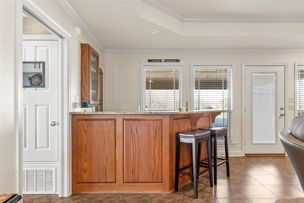 231 Trlica Road West, TX 76691 - Photo 11 of 36 This inviting oak bar area is perfect for entertaining, featuring ample storage along with a built-in ice maker and wine cooler for added convenience and functionality.