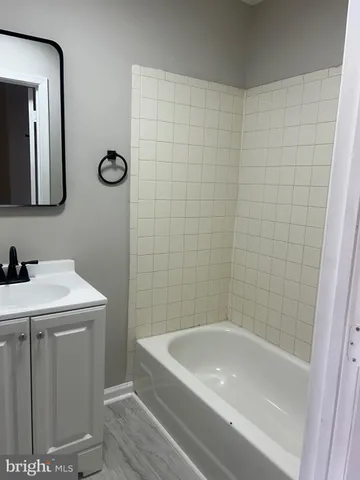 a bathroom with a tub a sink and mirror
