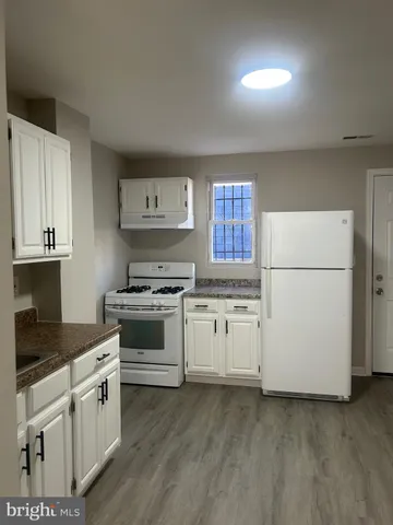 a kitchen with granite countertop white cabinets and white appliances