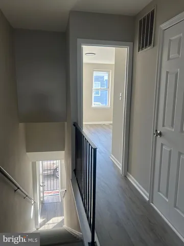 a view of a hallway with wooden floor and stairs