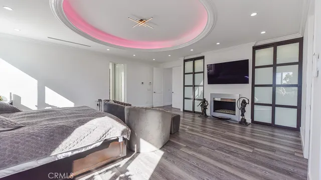 a spacious bedroom with a bed and a flat screen tv