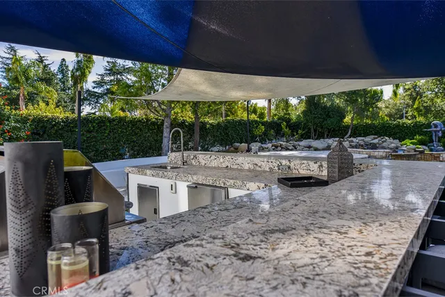 a view of a patio with chairs under an umbrella