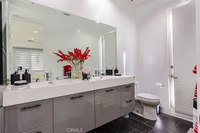a bathroom with a double vanity sink mirror and toilet