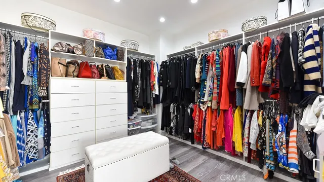 a view of walk in closet with clothes