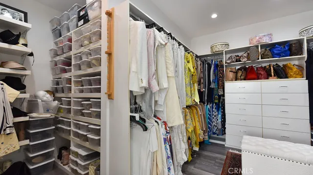 a view of walk in closet with clothes and shoes