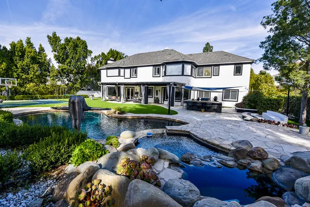 a view of a house with garden and sitting area