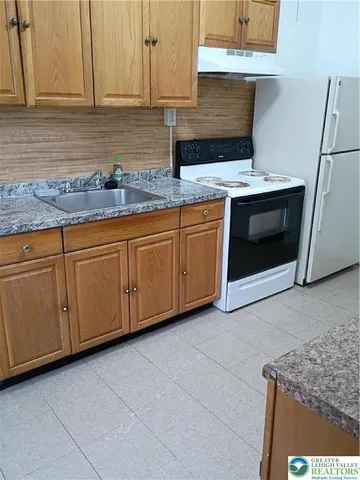 a kitchen with granite countertop cabinets stainless steel appliances and a counter space