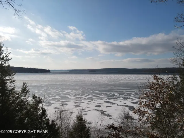 a kitchen with stainless steel appliances granite countertop a dining table chairs refrigerator and microwave