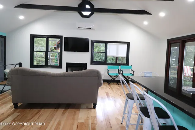 a living room with furniture a flat screen tv and a table