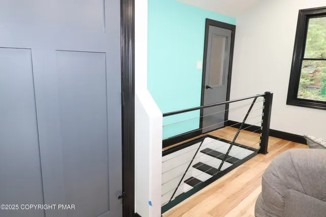 a view of staircase with wooden floor and white walls
