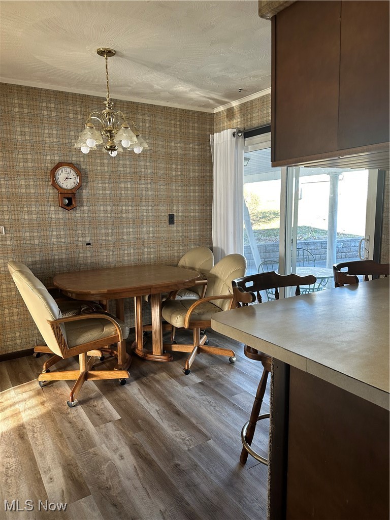 314 Devon Road Woodsfield, OH 43793 - Photo 16 of 50 Dining room with LVF flooring, a chandelier, and ornamental molding and sliding door
