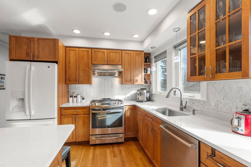 35-37 Presentation Road Boston, MA 02135 - Photo 19 of 29 a kitchen with stainless steel appliances a sink a stove a refrigerator cabinets and a counter top space