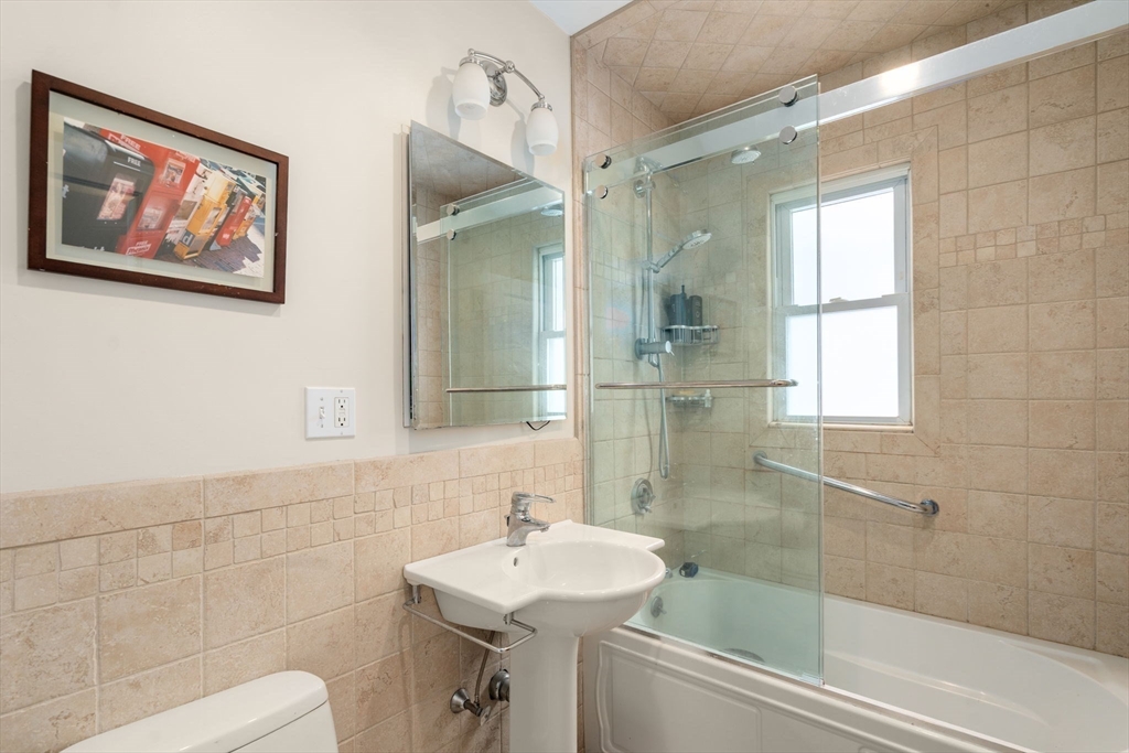35-37 Presentation Road Boston, MA 02135 - Photo 20 of 29 a bathroom with a sink mirror and a shower