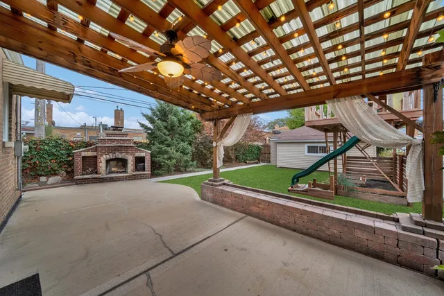 a view of a house with a yard and large tree