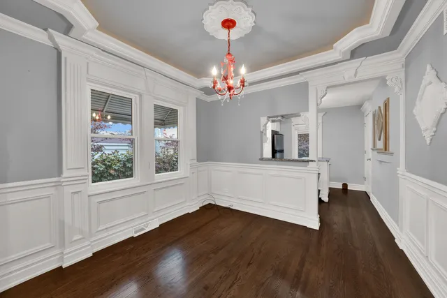 a view of a hallway with wooden floor and a kitchen