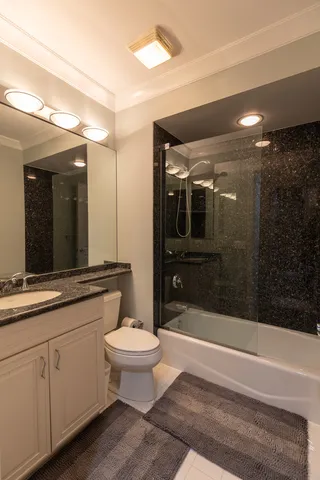 a bathroom with a sink a toilet a mirror and shower