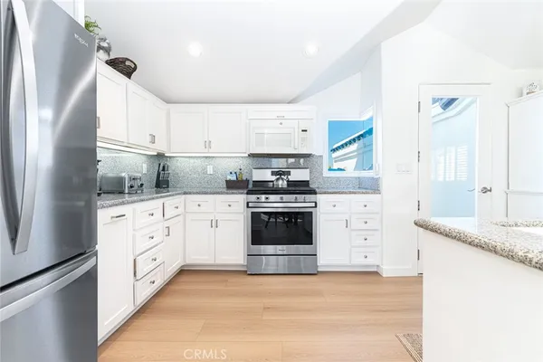 a kitchen with white cabinets and white appliances