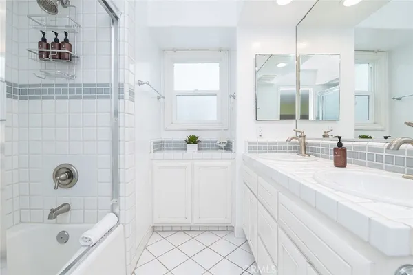 a bathroom with a granite countertop sink mirror and bathtub