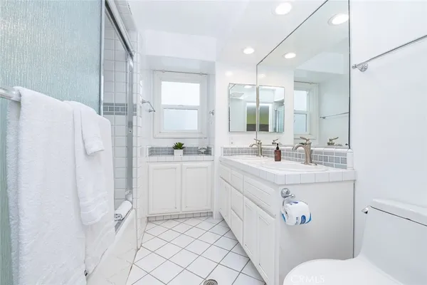 a bathroom with a sink mirror vanity and toilet