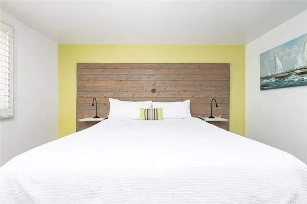 a bedroom with a bed and a painting on the wall