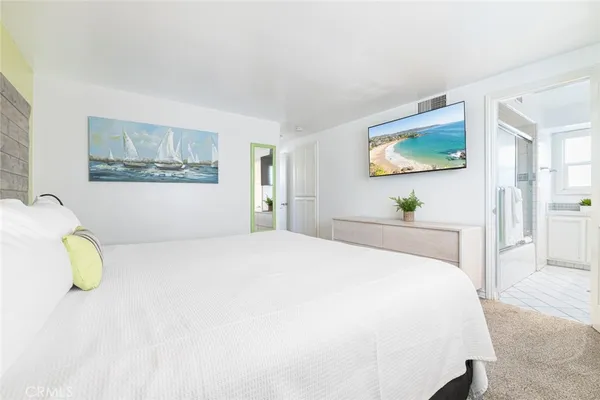 a bedroom with a bed and painting on the wall