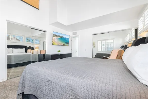 a bedroom with a large bed and a view of kitchen