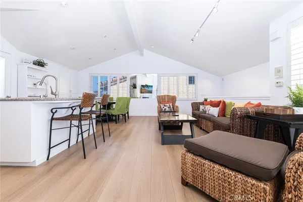 a living room with furniture a dining table and chairs with wooden floor