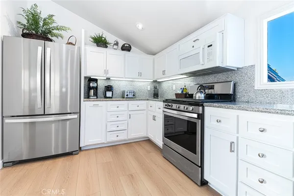 a kitchen with stainless steel appliances white cabinets and a refrigerator