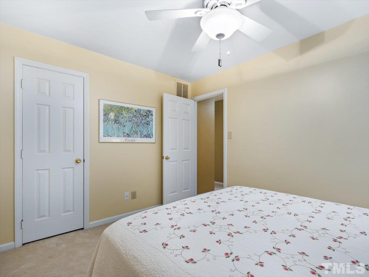 2868 Wycliff Road Raleigh, NC 27607 - Photo 17 of 28 a bedroom with a bed and a chandelier