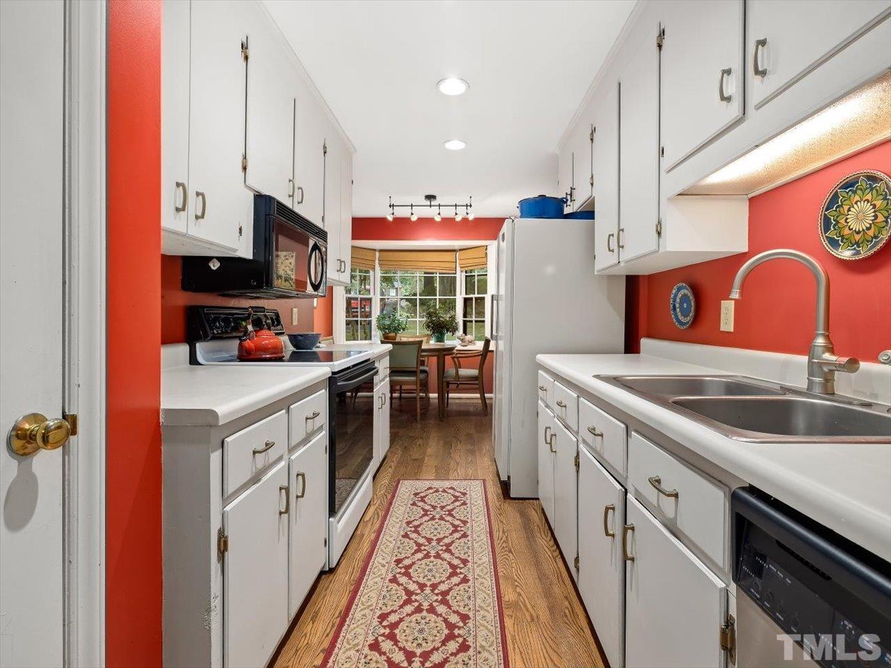2868 Wycliff Road Raleigh, NC 27607 - Photo 9 of 28 a kitchen with granite countertop a sink a counter top space stainless steel appliances and cabinets
