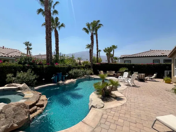 a view of a house with backyard and sitting area