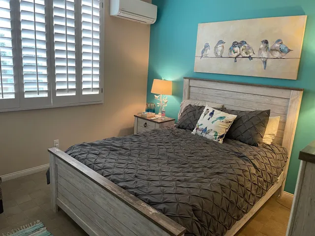 a bed sitting in a bedroom next to a window