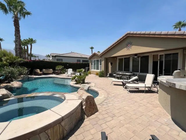 a view of swimming pool with outdoor seating and a potted plant