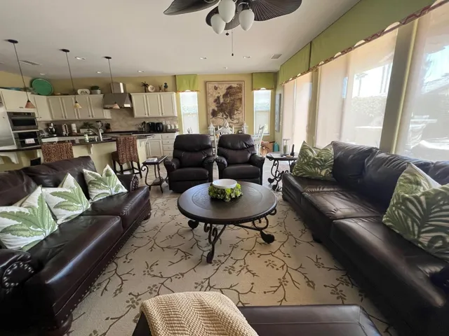 a living room with furniture kitchen and a large window